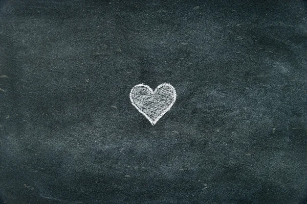 Hand drawing heart shape symbol on blackboard — Stockfoto