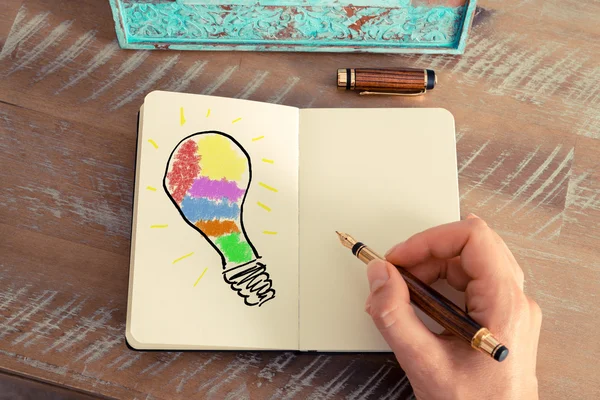 Жінка рука малює барвисту лампочку — стокове фото