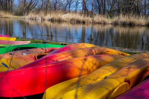 Group of canoes and rental kayak on the canal shore in Zoeterwoude, Leiden, Netherlands