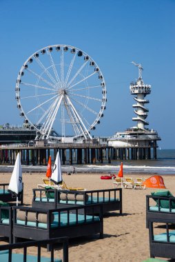 Yazın sonunda sahilde. Hollanda, Lahey 'de, feribot tekerleği ve arka planda bungy kulesi olan kumsal.. 