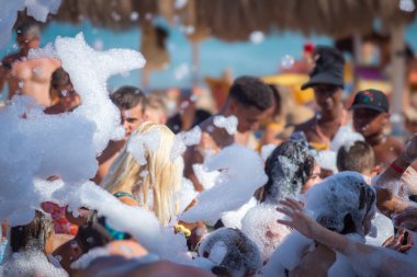 Hurghada, Mısır 'da canlı bir köpük partisi, kalın kabarcıklarla kaplı bir kalabalığı gösteriyor, gülüyor ve sahildeki parlak güneşin altında neşeli yaz atmosferinin tadını çıkarıyorlar.