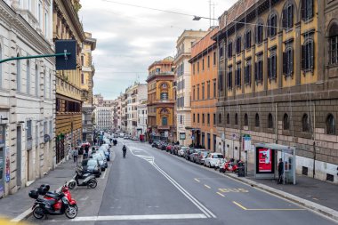 18 Ocak 2026 Roma İtalya: İnsanlar Roma katmanlı kentsel mimaride günlük hareketleri yansıtan taş sütunlar, yüksek tavanlar ve asılı lambalarla tarihi bir atari salonunun altında yürüyor