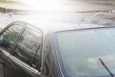 Yağmur damlaları bir araba yüzeyinde, oto yıkama, otomatik araç yıkama arabaya siyah