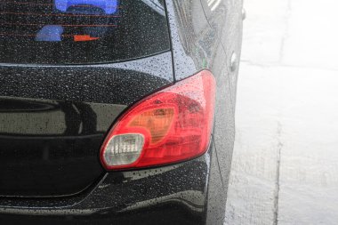 Yağmur damlaları bir araba yüzeyinde, oto yıkama, otomatik araç yıkama arabaya siyah