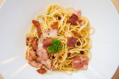Pastırmalı spagetti, maydanoz ve parmesan peyniri taze biber, fesleğen yaprağı. Beyaz tabakta Carbonara makarnası. İtalyan gıda konsepti.