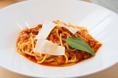 Pastırmalı spagetti, maydanoz ve parmesan peyniri taze biber, fesleğen yaprağı. Beyaz tabakta Carbonara makarnası. İtalyan gıda konsepti.