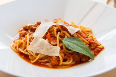 Pastırmalı spagetti, maydanoz ve parmesan peyniri taze biber, fesleğen yaprağı. Beyaz tabakta Carbonara makarnası. İtalyan gıda konsepti.