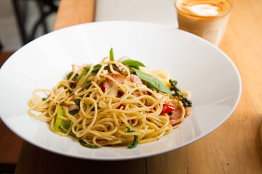 Pastırmalı spagetti, maydanoz ve parmesan peyniri taze biber, fesleğen yaprağı. Beyaz tabakta Carbonara makarnası. İtalyan gıda konsepti.