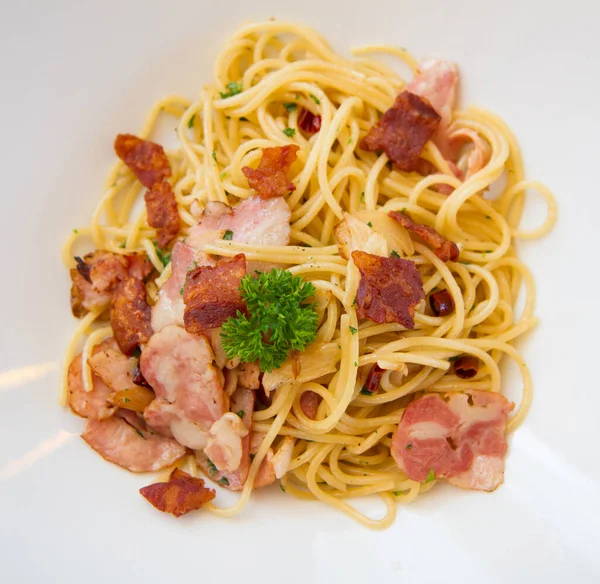 stock image spaghetti spicy with bacon, parsley and parmesan cheese Fresh pepper, Basil leaf . Pasta Carbonara on white plate. Italian food concept.