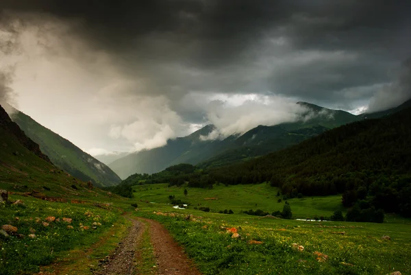 Strada sterrata nelle montagne del Caucaso prima della pioggia — Foto Stock