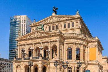 Frankfurt 'taki eski opera binasının tarihi binası ilkbahar güneşli. Şehrin merkezindeki halka açık meydanda binanın önünde sokak lambaları var.