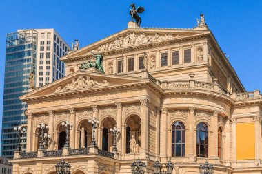 Frankfurt 'taki eski opera binasının tarihi binası ilkbahar güneşli. Şehir merkezinde halka açık bir meydanda, arkasında ticari ve ofis binaları var.