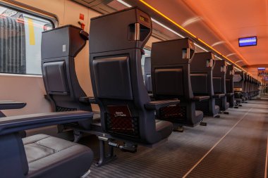 Demiryolu vagonundaki bireysel koltuklar. Alman demiryolundan birinci sınıf boş banklar. Merkez koridor tren kompartımanında yolcu yok. Koridorda aydınlatılmış tavan ve dijital uyarı panoları