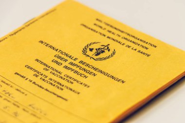 WHO aşı kartının yan görüntüsü. Sarı kart, gerekli aşıların kanıtı. Dünya Sağlık Örgütü 'nün uluslararası alanda tanınan sağlık pasaportu