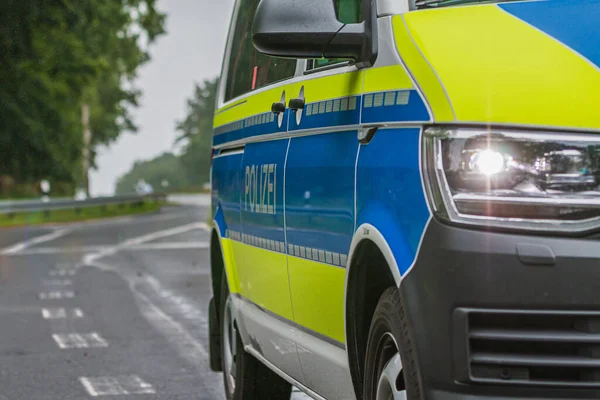 ドイツの警察車両の一部ビュー ヘッドライトをオンにし 乗客側から体に警察のレタリング 反射縞のある青の背景と黄色 — ストック写真