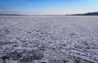 Soğuk bir günde, gün batımından birkaç saat önce donmuş göl..