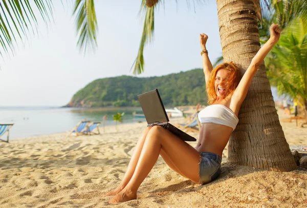 Happy girl on the beach with a laptop — Stock Photo, Image