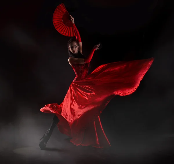 Женщина в длинном красном платье позирует в студии — стоковое фото