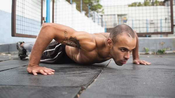 Athlete doing squeezing at the stadium — Stock Photo, Image