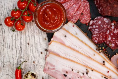 Farklı türde tütsülenmiş sosis ve eti ahşap arka planda dilimlemek. en üstteki görünüm