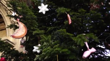 Bir Noel ağacının dallarında tahta oyuncaklar, bir ay şeklinde, altı köşeli bir yıldız ve diğerleri.