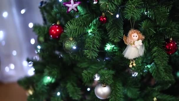 Kvinnan dekorerar julgranen med bollar. — Stockvideo