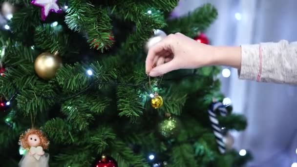 La mujer decora el árbol de Navidad con bolas. — Vídeos de Stock