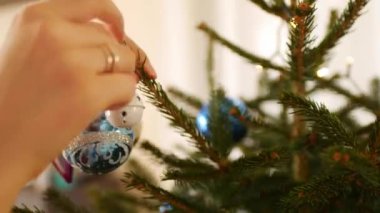 Bir Noel ağacını süsleyen kadın ellerinin yakın çekimi.