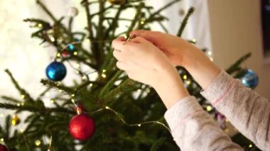 Kadınların elleri Noel ağacını süslerken birbirine yakındır..