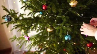 Kadınların elleri Noel ağacını süslerken birbirine yakındır..