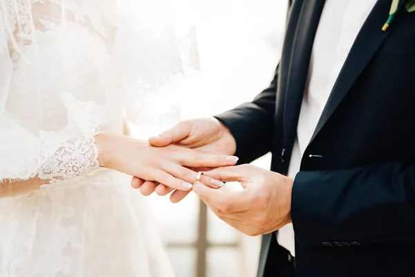 Der Bräutigam legt den Ring während der Hochzeitszeremonie an den Finger der Braut — Stockfoto