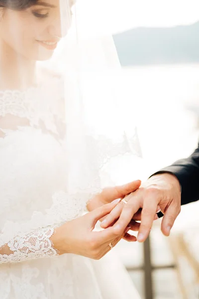 A menyasszony felteszi a gyűrűt a vőlegény ujjára az esküvő alatt. — Stock Fotó