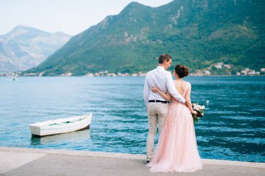 Gelin ve damat Perast 'taki iskelede kucaklaşıyorlar.