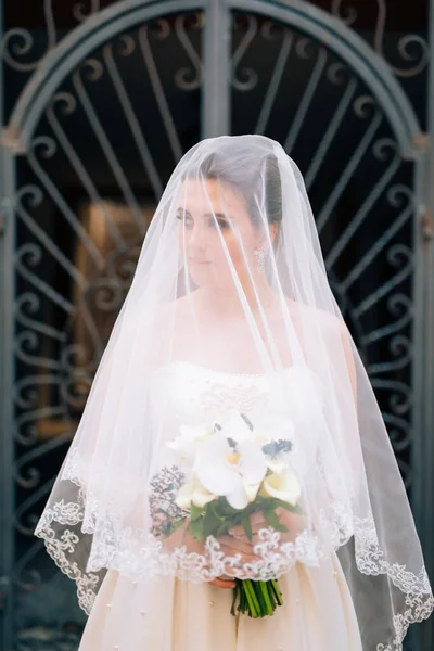 Pengantin cantik ditutupi dengan kerudung dengan buket pengantin — Stok Foto