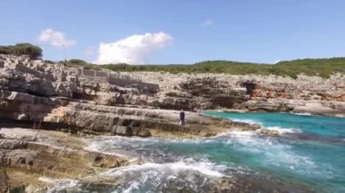 Gelin ve damat Lustica 'nın kayalık sahillerinde kucaklaşıyorlar.