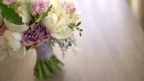 Bridal bouquet of white peonies, purple roses, freesia, artemisia and laurel — Stock Video