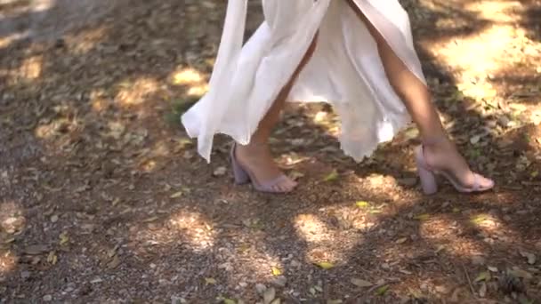 Anmutige Beine der Braut in Sandalen, flatternder Rock des Brautkleides — Stockvideo