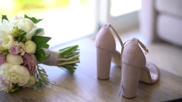 Los zapatos de las novias están en el suelo junto al ramo de novias — Vídeos de Stock