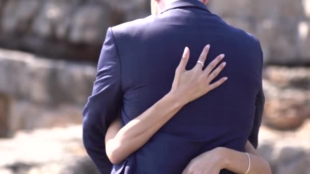 The groom embraces the bride, the brides hands gently stroke the grooms back — Stock Video