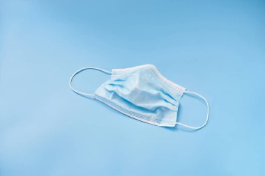 Mavi arka planda yalıtılmış tıbbi yüz maskesi. Kişisel koruma ekipmanları.