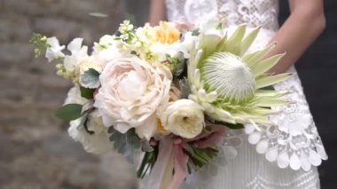 Gelin bir buket tutuyor, yakın plan.