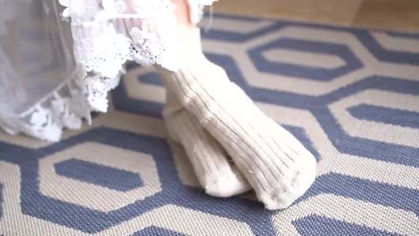 De bruiden benen in grappige sokken gluren uit van onder de peignoir tijdens de bijeenkomst — Stockvideo