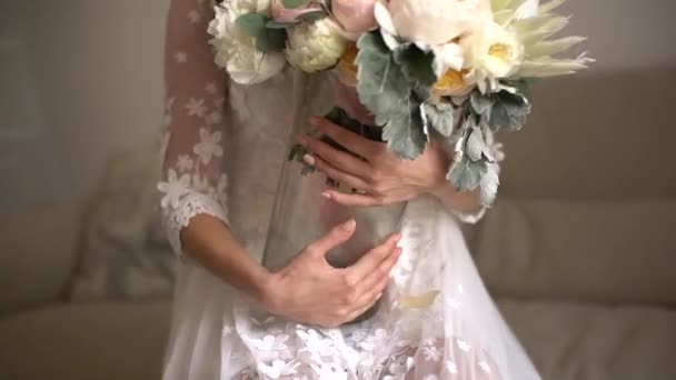 Panna młoda trzyma wazon z bukietem ślubnym w rękach — Wideo stockowe