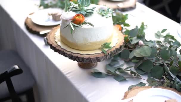 Γαμήλια τούρτα διακοσμημένη με λουλούδια στο τραπέζι σε γαμήλιο δείπνο — Αρχείο Βίντεο