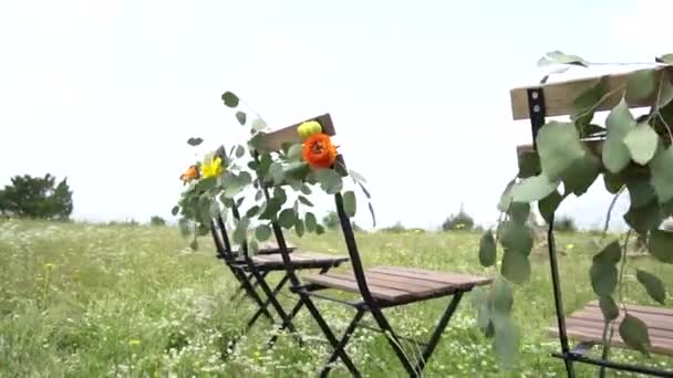 Local do casamento, cadeiras decoradas com flores e folhas de eucalipto — Vídeo de Stock