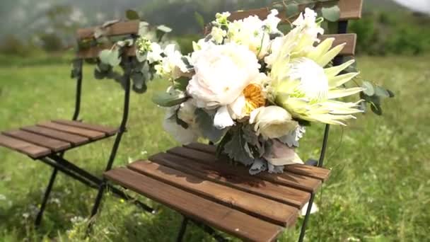 Cadeiras decoradas com flores com buquê de casamento no assento — Vídeo de Stock