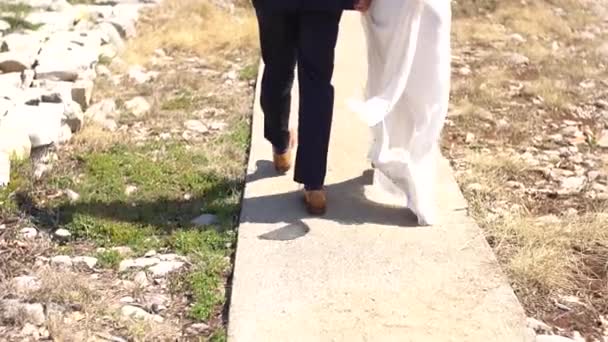 Pés da noiva e noivo andando ao longo da estrada — Vídeo de Stock