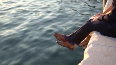 Gelinin ve damadın ayakları iskelede oturuyor.