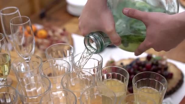 Banquete de bodas al aire libre, el hombre vierte bebidas en vasos — Vídeos de Stock