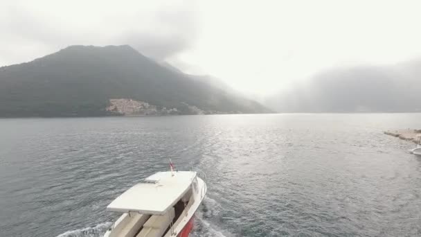 Egy turistahajó vitorlázik a Kotori-öböl mentén Perast közelében — Stock videók